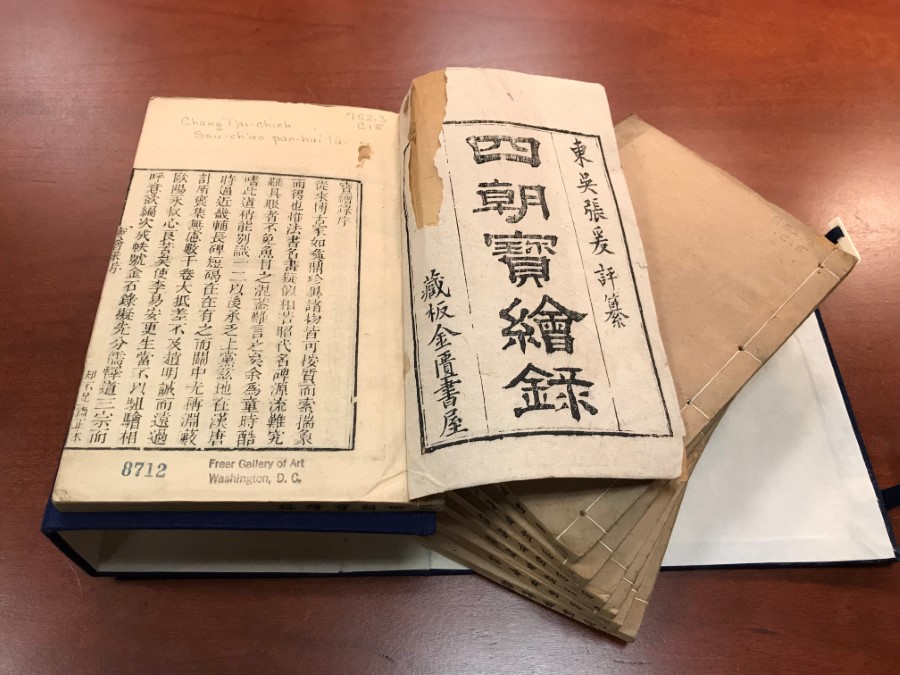 Image of the cover page of Zhang Taijie's 'A Record of Treasured Paintings'. Book open against a dark wood desk.