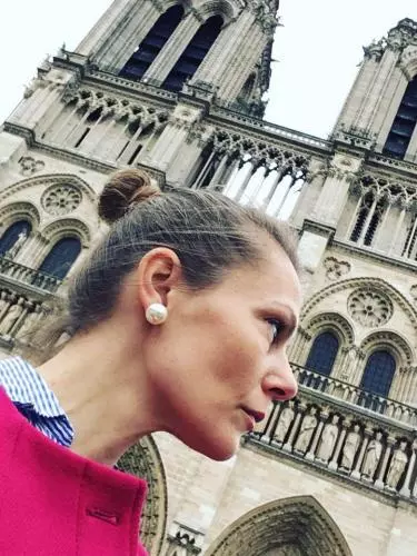 Headshot of Leah Clark in profile in front of Notre Dame in Paris. 
