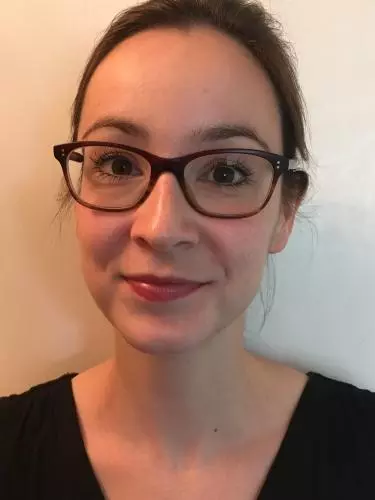 Photo of Kirsten MacFarlane smiling to camera in front of a white background.