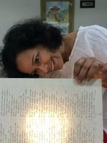 Photo of Nandini Das looking at book. 