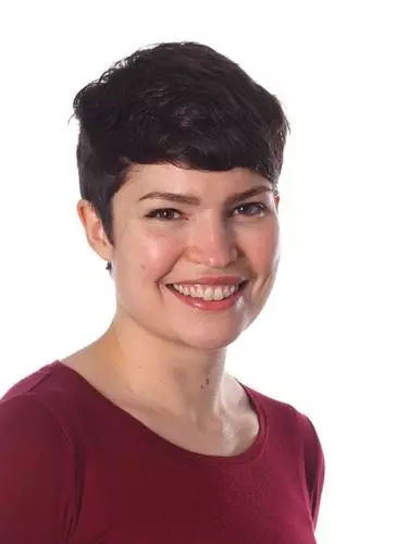 Photo of Jennifer Oliver smiling to camera, sitting in front of a white background. 