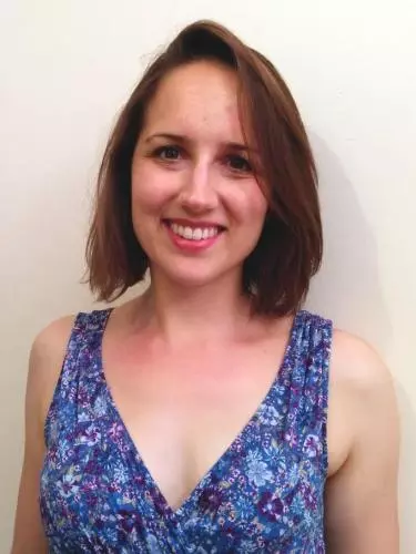 Photo of Jessica Goodman smiling to camera, standing on front of a white background. 