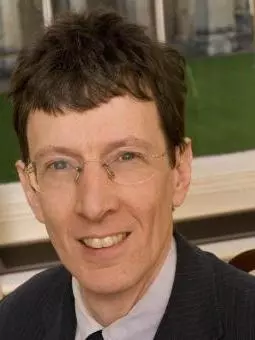 Photo of Colin Burrow smiling to camera.