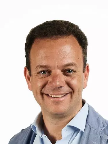 Photo of Filippo de Vivo in front of a white background smiling to camera