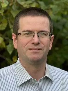 Professor Ian Williams standing against a verdant background