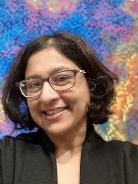 Professor Nandini Chatterjee Standing against a multicoloured background