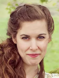 Photo of Rebecca Wallace. Smiling directly at the camera against a grassy background.