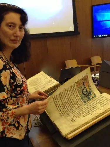 Prof. Thea Gomelauri inspecting a manuscript in the weston library