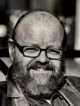 Black and white photo of Wes Williams smiling to camera.