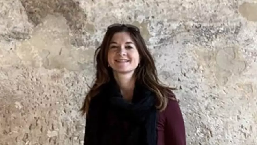 Photo of Emanuela Vai smiling to camera with rocky surface behind
