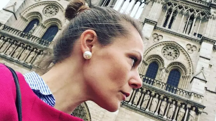 Headshot of Leah Clark in profile in front of Notre Dame in Paris. 