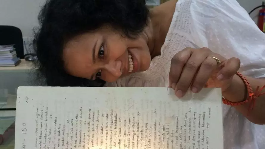 Photo of Nandini Das looking at book. 