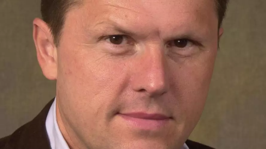 Photo of Robert Iliffe looking to camera in front of a neutral background.