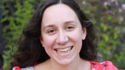 Photo of Sadie Jarrett, outside, smiling to camera. 