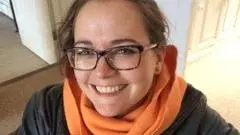 Photo of Sophie Nicholls looking upwards to camera, smiling. 
