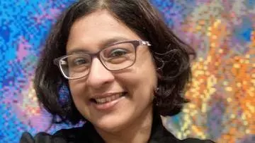 Professor Nandini Chatterjee Standing against a multicoloured background