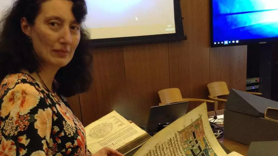 Prof. Thea Gomelauri inspecting a manuscript in the weston library