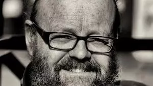 Black and white photo of Wes Williams smiling to camera.